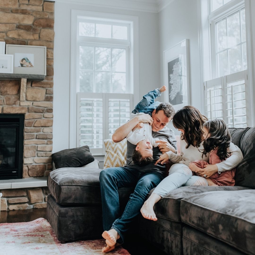 Family-of-Four-Sitting-and-Playing-on-Couch